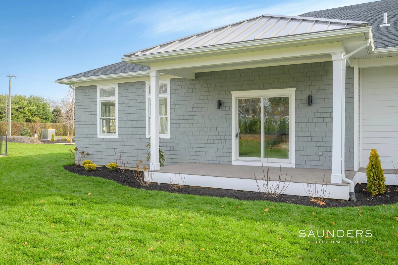 Grey and white building with green lawn.